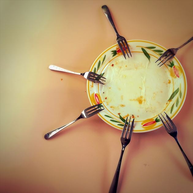 an empty plate with a bunch of forks on it